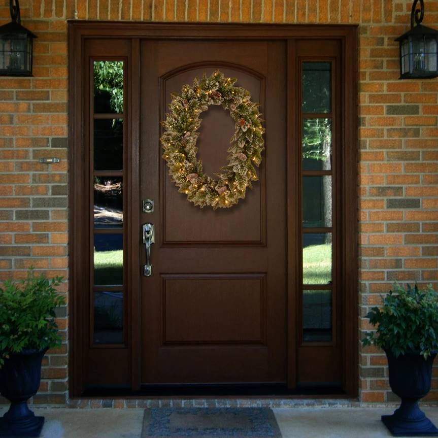 Pre-Lit Artificial Christmas Oval Wreath, Green, Glittery Bristle Pine, White Lights, Decorated with Pine Cones, Frosted Branches, Christmas Collection, 21 Inches National Tree CompanyLBRH244